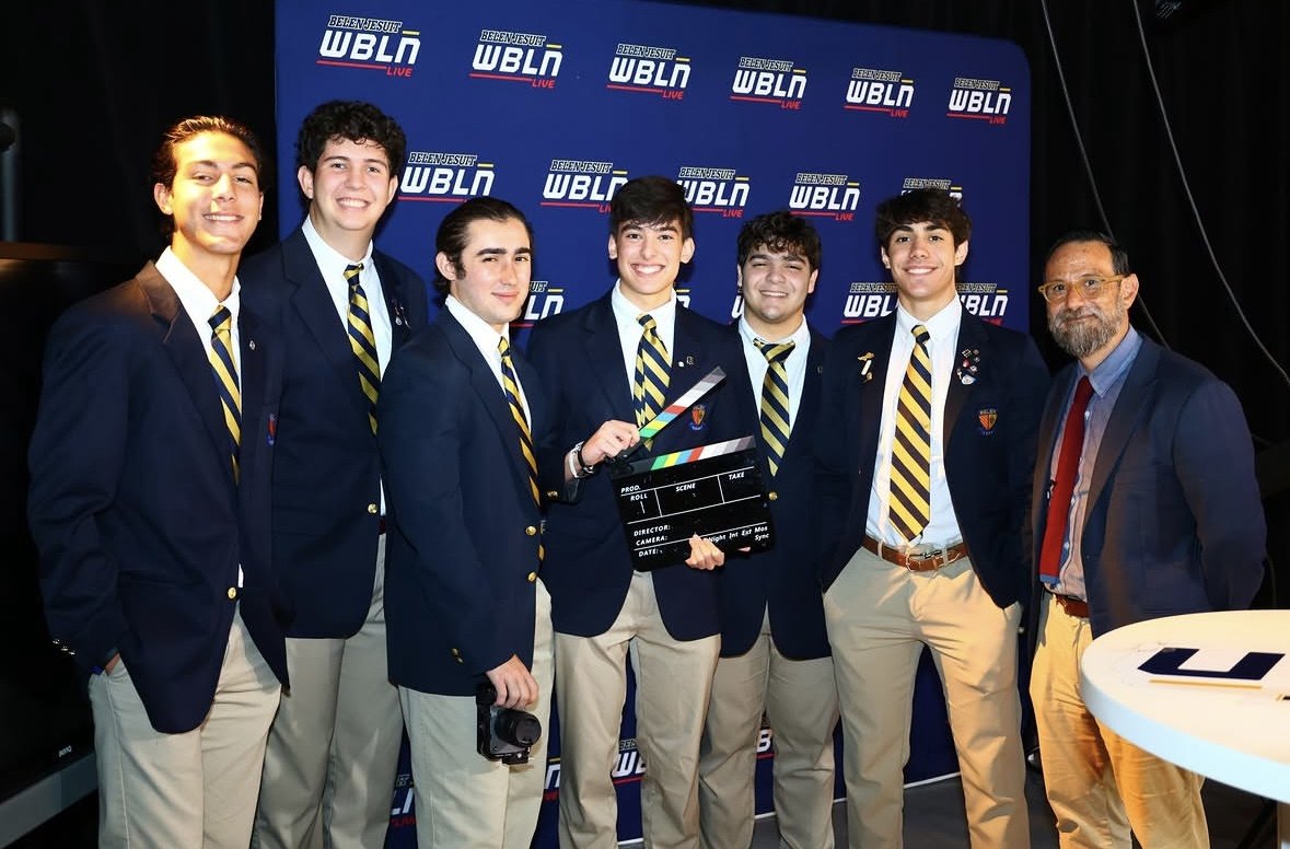 The Stalling team holding a clapperboard in front of the WBLN backdrop